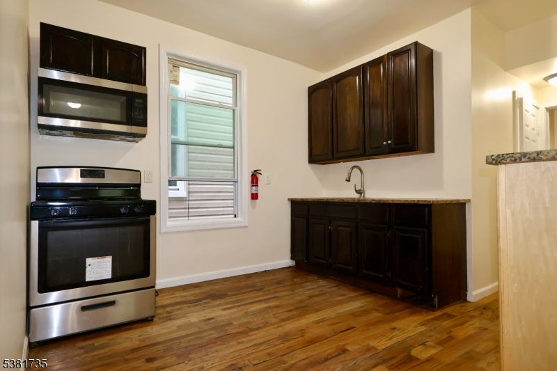 112 Chadwick Avenue, Unit 2 Newark, NJ 07108 - Photo 6 of 13 a kitchen with a stove and a microwave