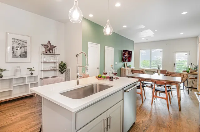 a kitchen with a sink a counter space appliances and wooden floor