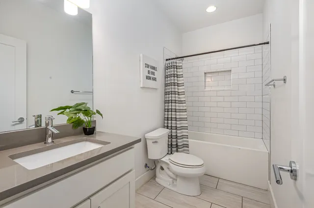 a bathroom with a granite countertop sink a toilet and shower