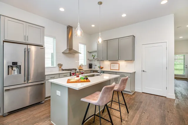 a kitchen with a refrigerator a stove a sink and a dining table