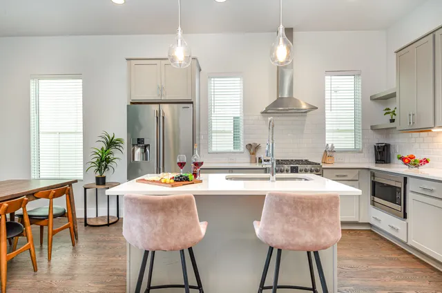 a kitchen with sink a refrigerator and chairs