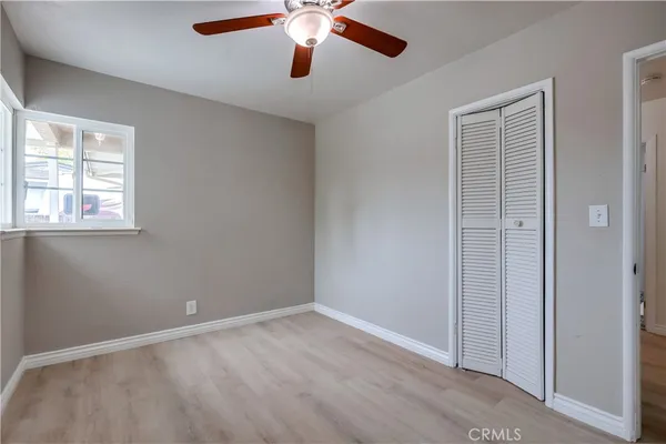 an empty room with a window and a ceiling fan