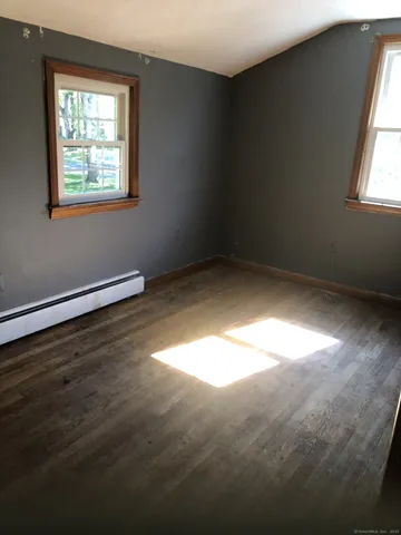 a view of a room with wooden floor and windows