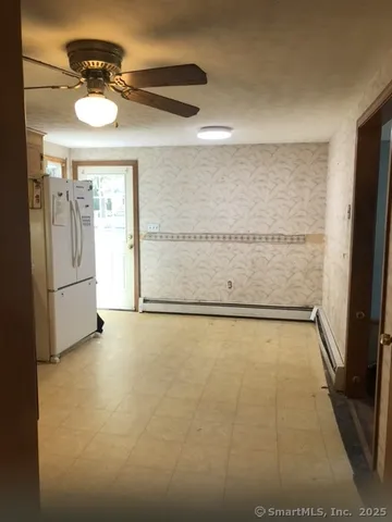 an empty room with a window and a chandelier fan