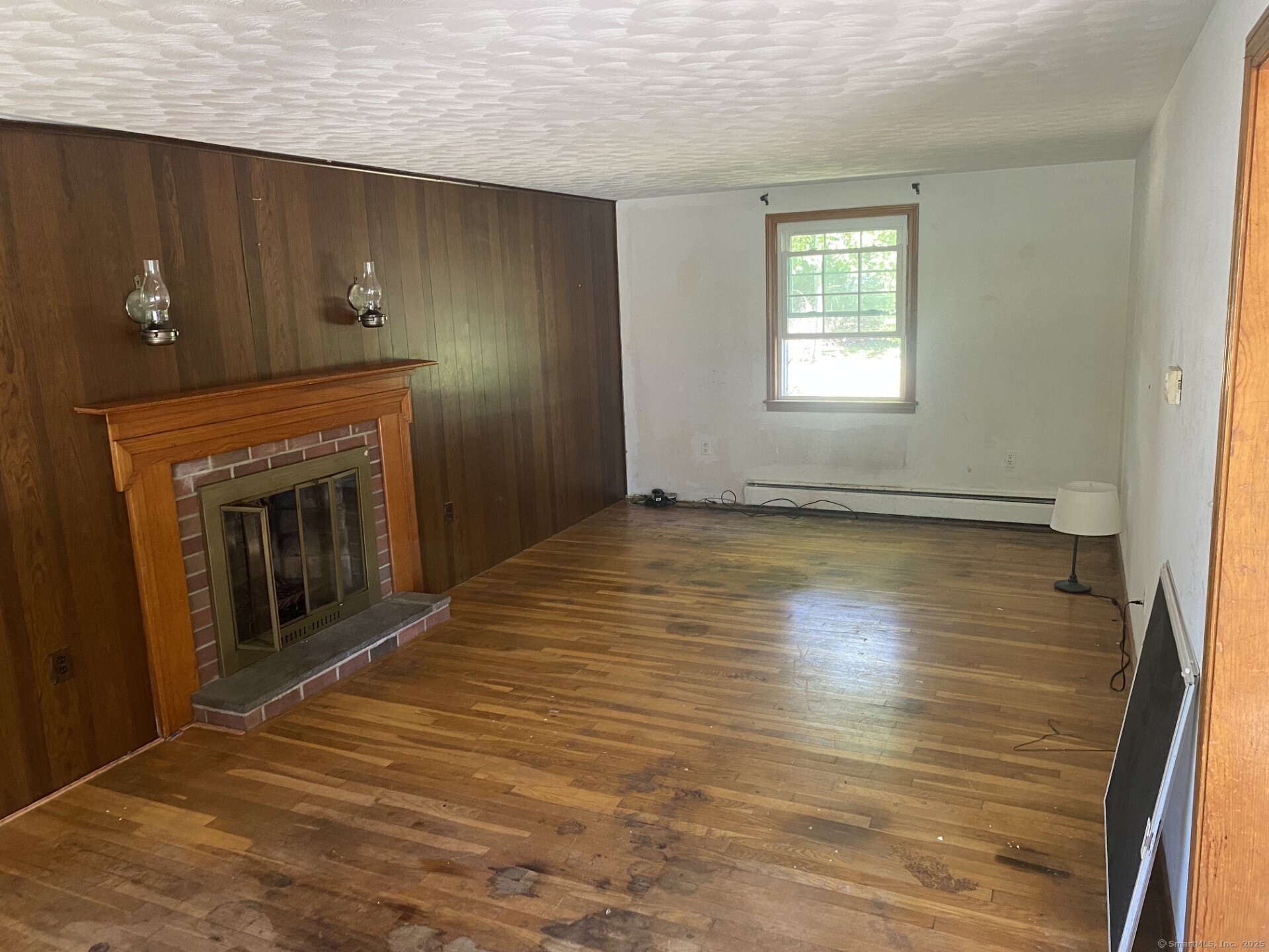 45 Monroe Road Enfield, CT 06082 - Photo 6 of 12 an empty room with wooden floor fireplace and windows