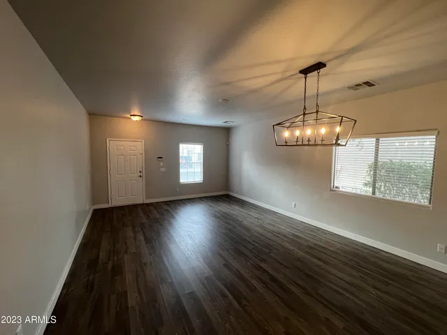 a view of empty room with wooden floor and window