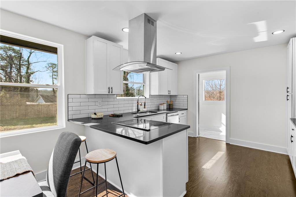 968 Bruce Circle Southeast Atlanta, GA 30316 - Photo 11 of 40 a kitchen with stainless steel appliances granite countertop a stove a refrigerator a sink a dining table and chairs with wooden floor