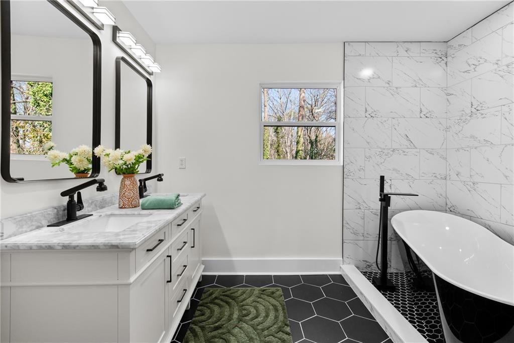 968 Bruce Circle Southeast Atlanta, GA 30316 - Photo 16 of 40 a bathroom with a double vanity sink a mirror and a bathtub