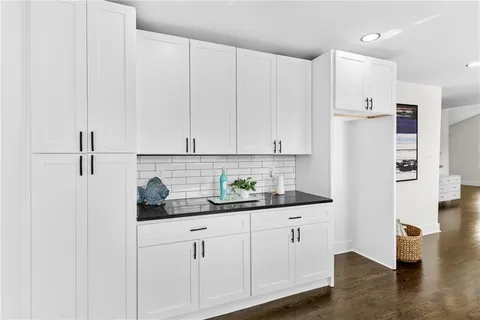 a kitchen with stainless steel appliances white cabinets and wooden floors