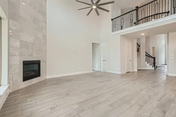 a view of an empty room with wooden floor and a fireplace