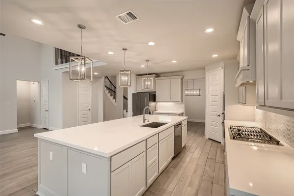 a kitchen with kitchen island a sink stainless steel appliances and refrigerator