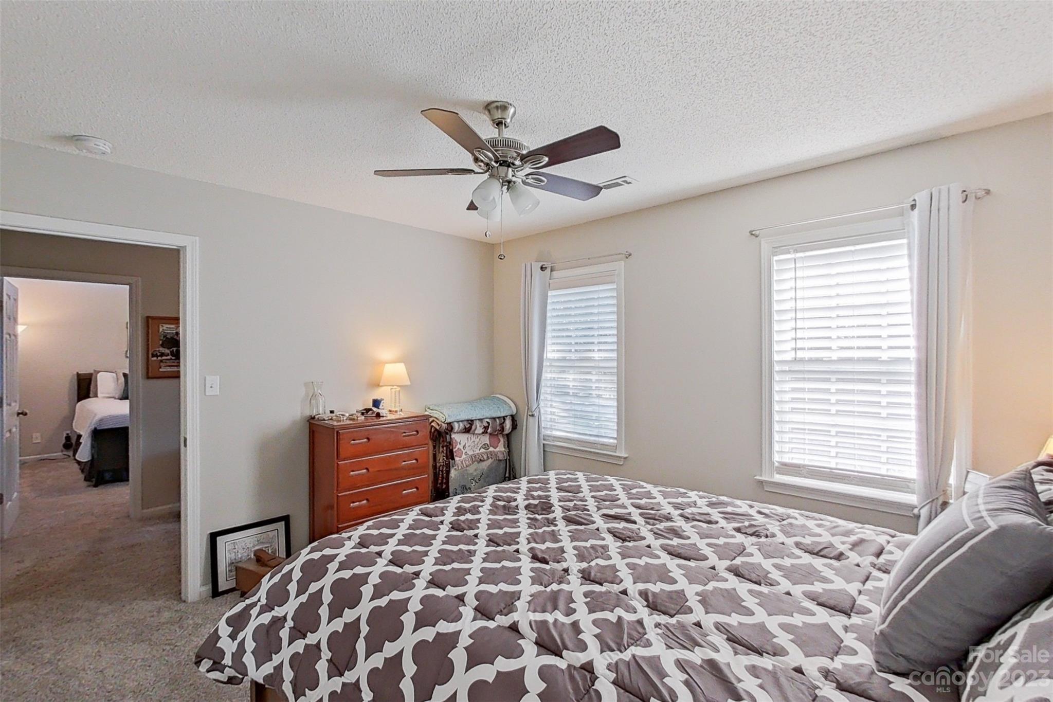 358 Maple Ridge Circle Salisbury, NC 28147 - Photo 33 of 48 a bedroom with a large bed and a chandelier
