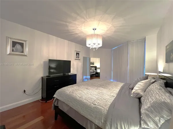 a bedroom with a bed and a flat screen tv