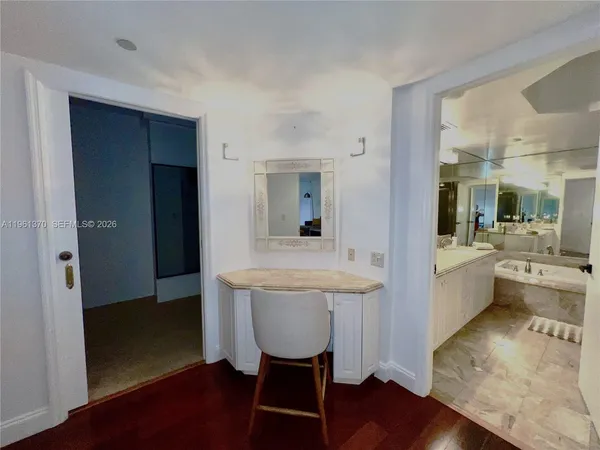 a room with dining table wooden floor and view kitchen
