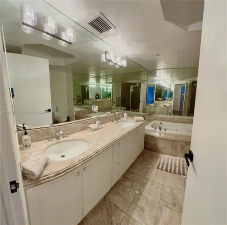 a bathroom with a sink double vanity granite and a large mirror