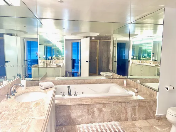 a bathroom with a tub sink and mirror