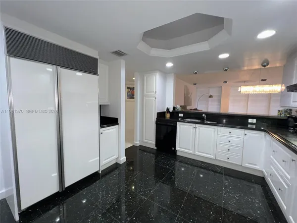 a kitchen with stainless steel appliances a refrigerator sink and white cabinets