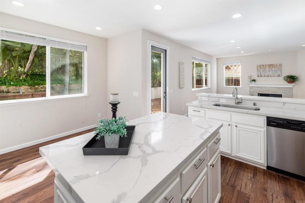 1577 Archer Road San Marcos, CA 92078 - Photo 16 of 53 a kitchen with a sink dishwasher and white cabinets with wooden floor