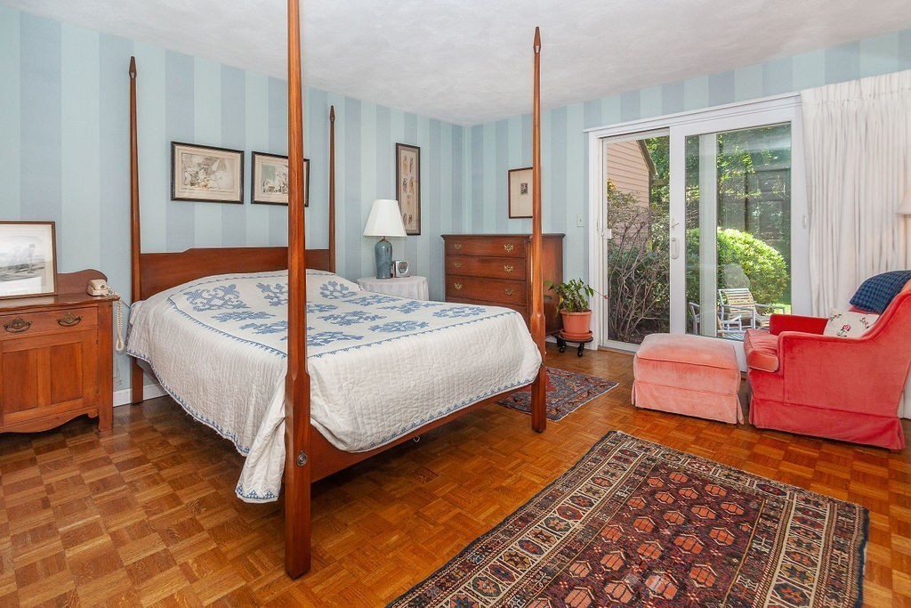 3 Potter Pond, Unit 3 Lexington, MA 02421 - Photo 10 of 20 a bedroom with a bed and wooden floor