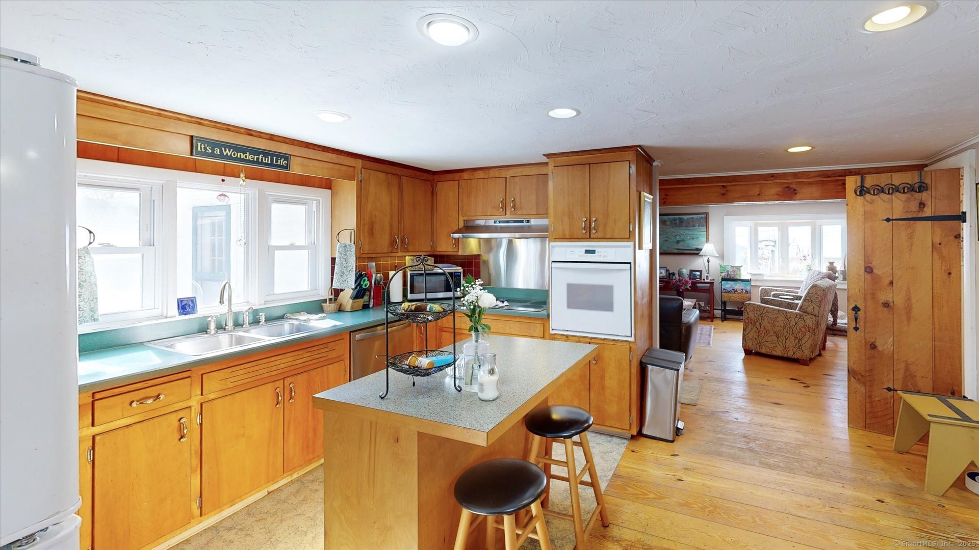 69 North Bedlam Road Chaplin, CT 06235 - Photo 9 of 40 a kitchen with a refrigerator a stove top oven a sink dishwasher and couches with wooden floor