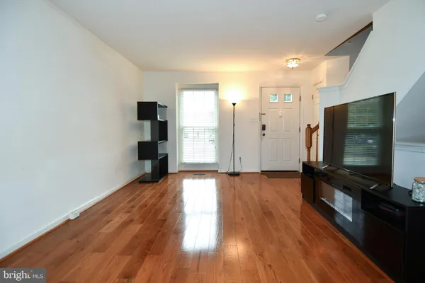 a view of a livingroom with wooden floor and a flat screen tv