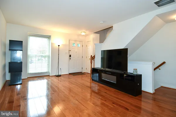 a view of a livingroom with wooden floor and a flat screen tv