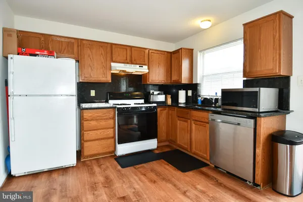 a kitchen with stainless steel appliances granite countertop a refrigerator sink and stove