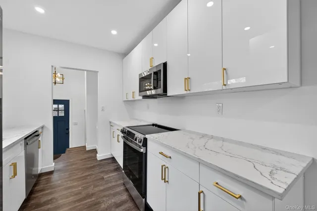 a kitchen with stainless steel appliances granite countertop a stove a sink and a microwave