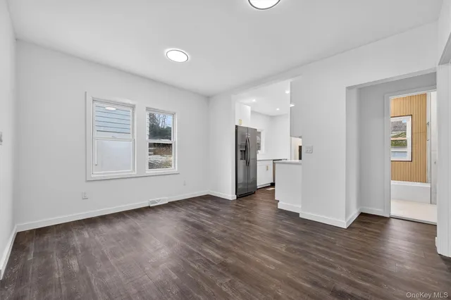 a view of empty room with wooden floor and window