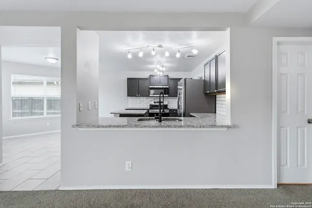 a kitchen with kitchen island a sink stainless steel appliances and cabinets