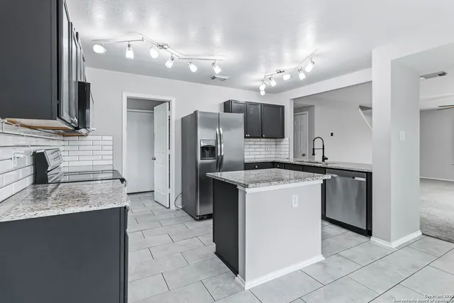 a large kitchen with cabinets and stainless steel appliances