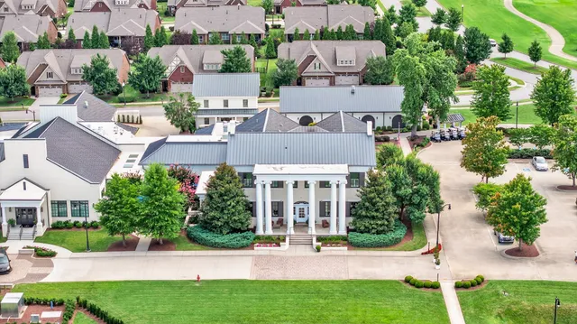 an aerial view of a house with a yard and outdoor seating