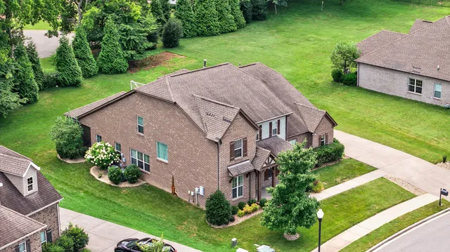 a aerial view of a house next to a big yard and large trees