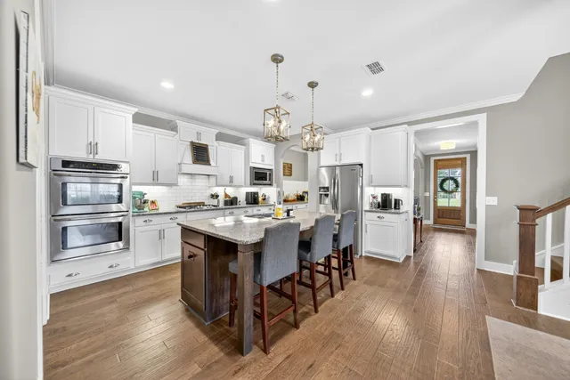 a large kitchen with lots of counter space a sink appliances and cabinets