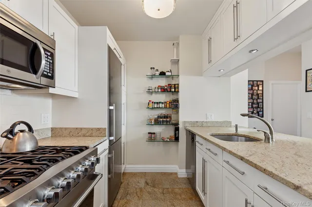 a kitchen with stainless steel appliances granite countertop a sink stove and cabinets