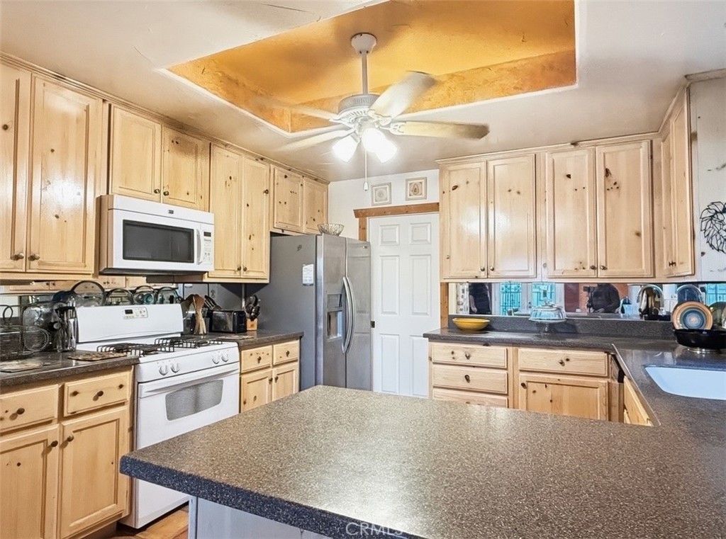 1932 South Barona Road Palm Springs, CA 92264 - Photo 9 of 19 a kitchen with white cabinets and stainless steel appliances