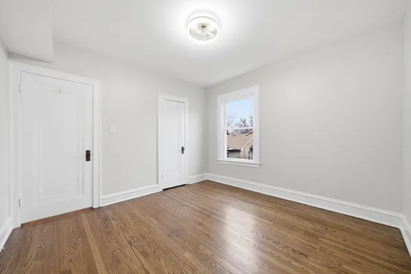 a view of room with window and wooden floor