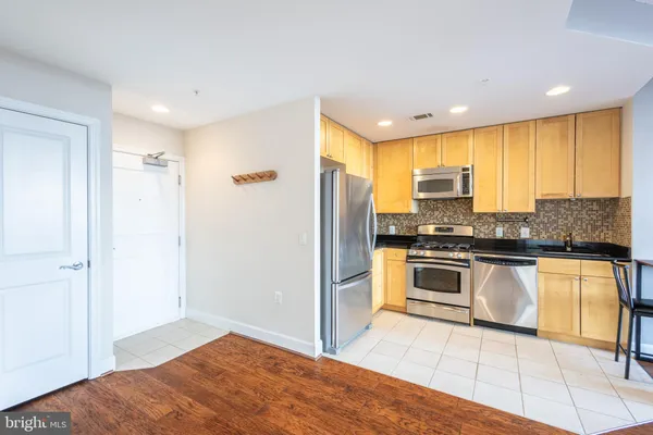 a kitchen with stainless steel appliances granite countertop a refrigerator and a sink
