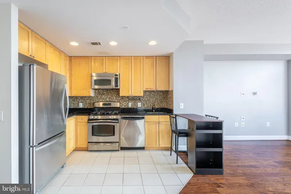 a kitchen with stainless steel appliances granite countertop a refrigerator stove and oven