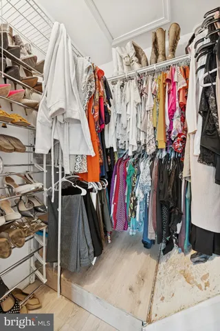 a view of walk in closet with clothes