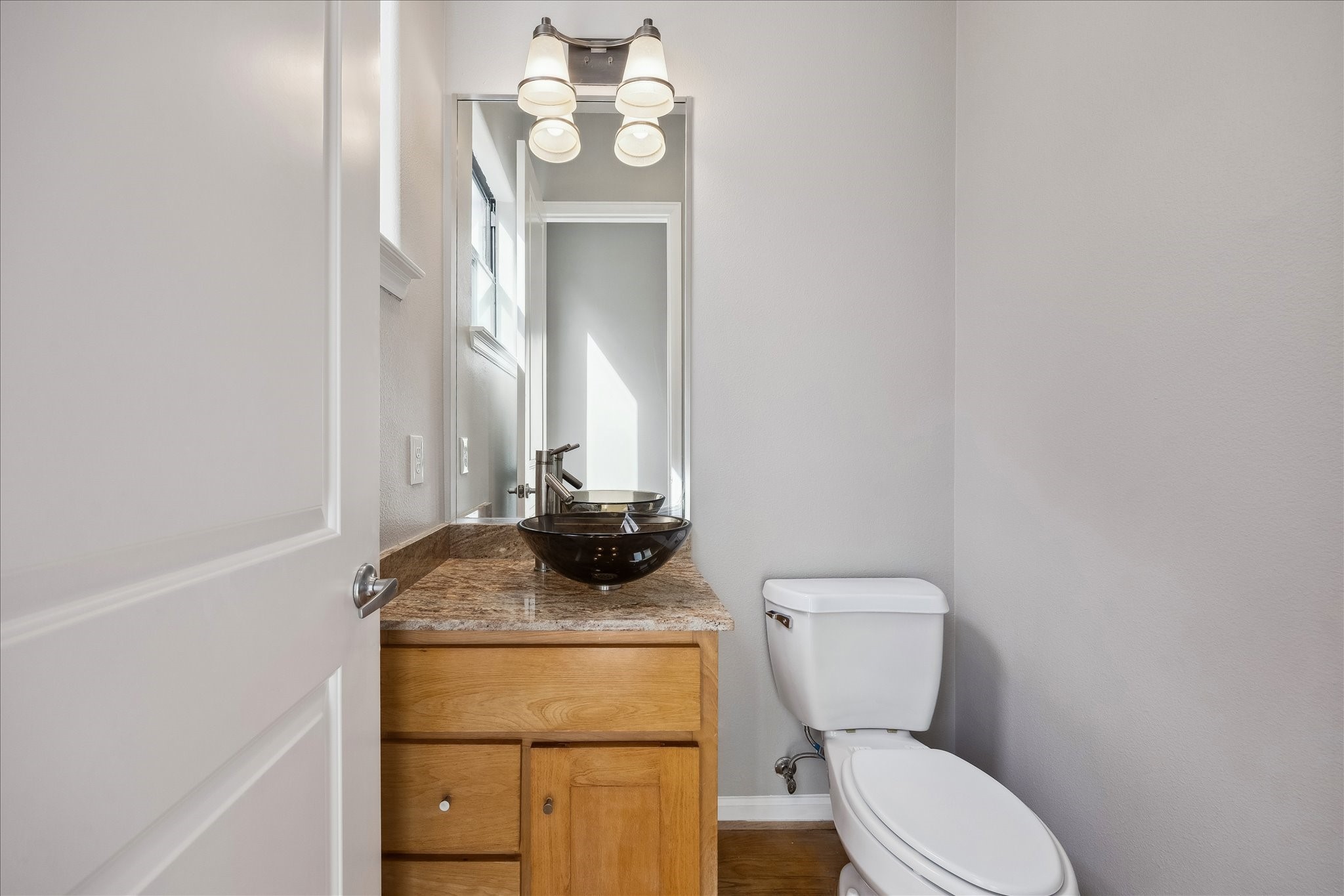 802 Waverly Street, Unit D Houston, TX 77007 - Photo 11 of 30 a bathroom with a toilet a sink and mirror