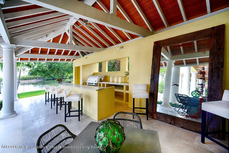 85 Curlew Road Manalapan, FL 33462 - Photo 22 of 30 a view of a patio with table and chairs potted plants with wooden floor and fence