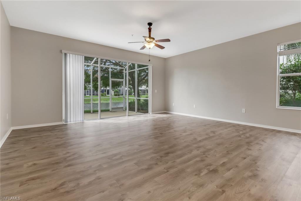 815 Hampton Circle, Unit 143 Naples, FL 34105 - Photo 12 of 30 a view of an empty room with wooden floor and a window