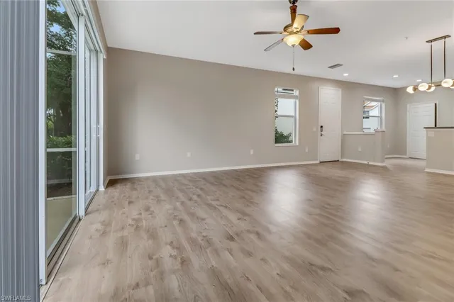 wooden floor in an empty room with a ceiling fan