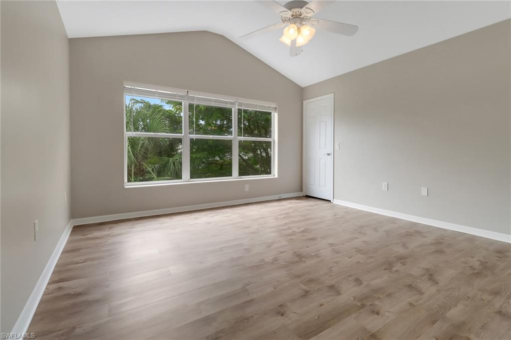 815 Hampton Circle, Unit 143 Naples, FL 34105 - Photo 20 of 30 an empty room with wooden floor and windows