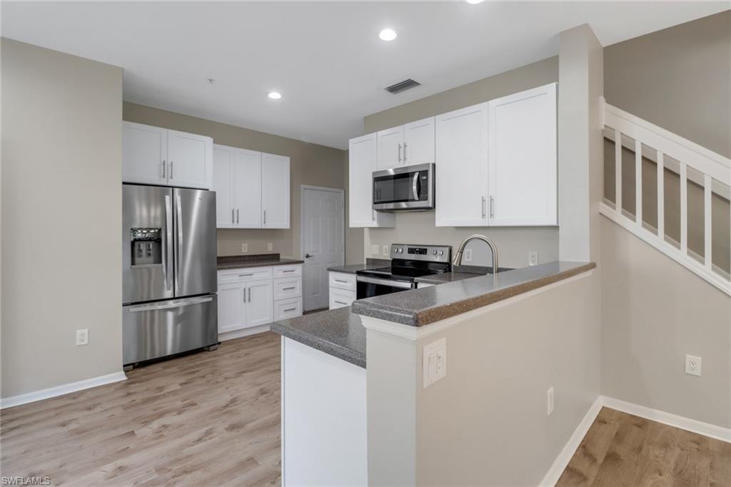 815 Hampton Circle, Unit 143 Naples, FL 34105 - Photo 3 of 30 a kitchen with a refrigerator stove and microwave