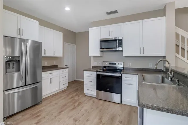 a kitchen with stainless steel appliances granite countertop a refrigerator stove a sink and microwave