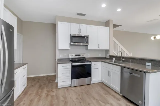 a kitchen with stainless steel appliances granite countertop a stove a sink and a refrigerator