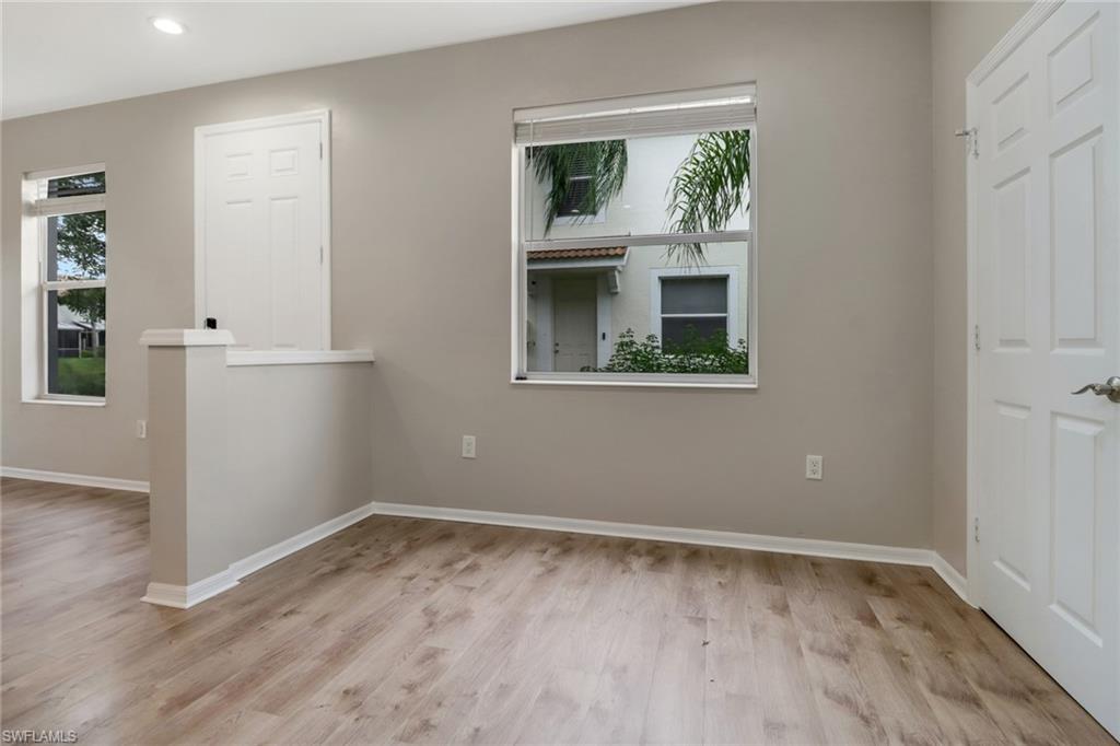 815 Hampton Circle, Unit 143 Naples, FL 34105 - Photo 6 of 30 a view of an empty room with wooden floor and a window