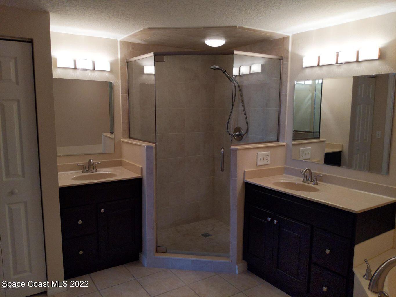 100 Riverside Drive, Unit 702 Cocoa, FL 32922 - Photo 14 of 33 a bathroom with a shower sink vanity and mirror